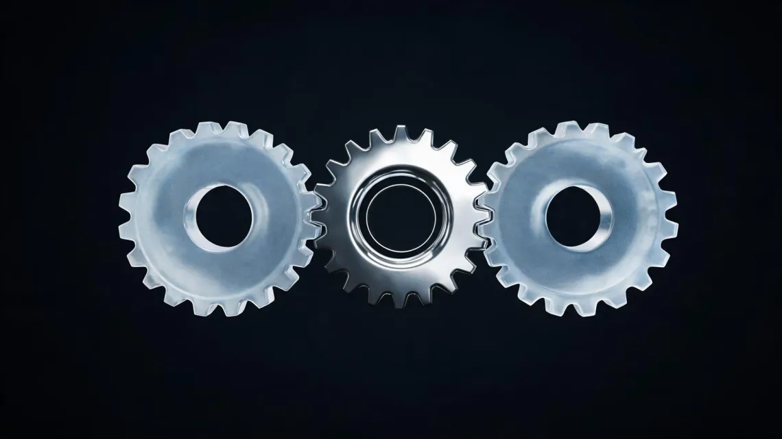 A chrome gear between two frosted-glass gears, on a black background.